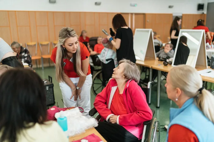 Eine Pflegefachkraft spricht mit einer älteren Frau in einer Pflegeeinrichtung